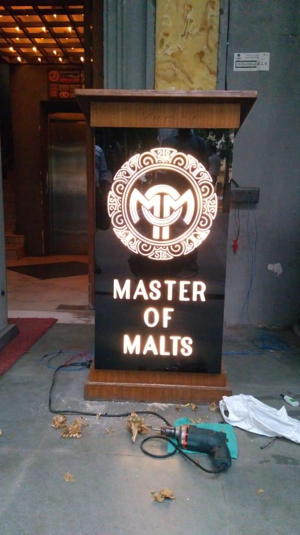 Master of Malts backlit logo sign on a wooden stand