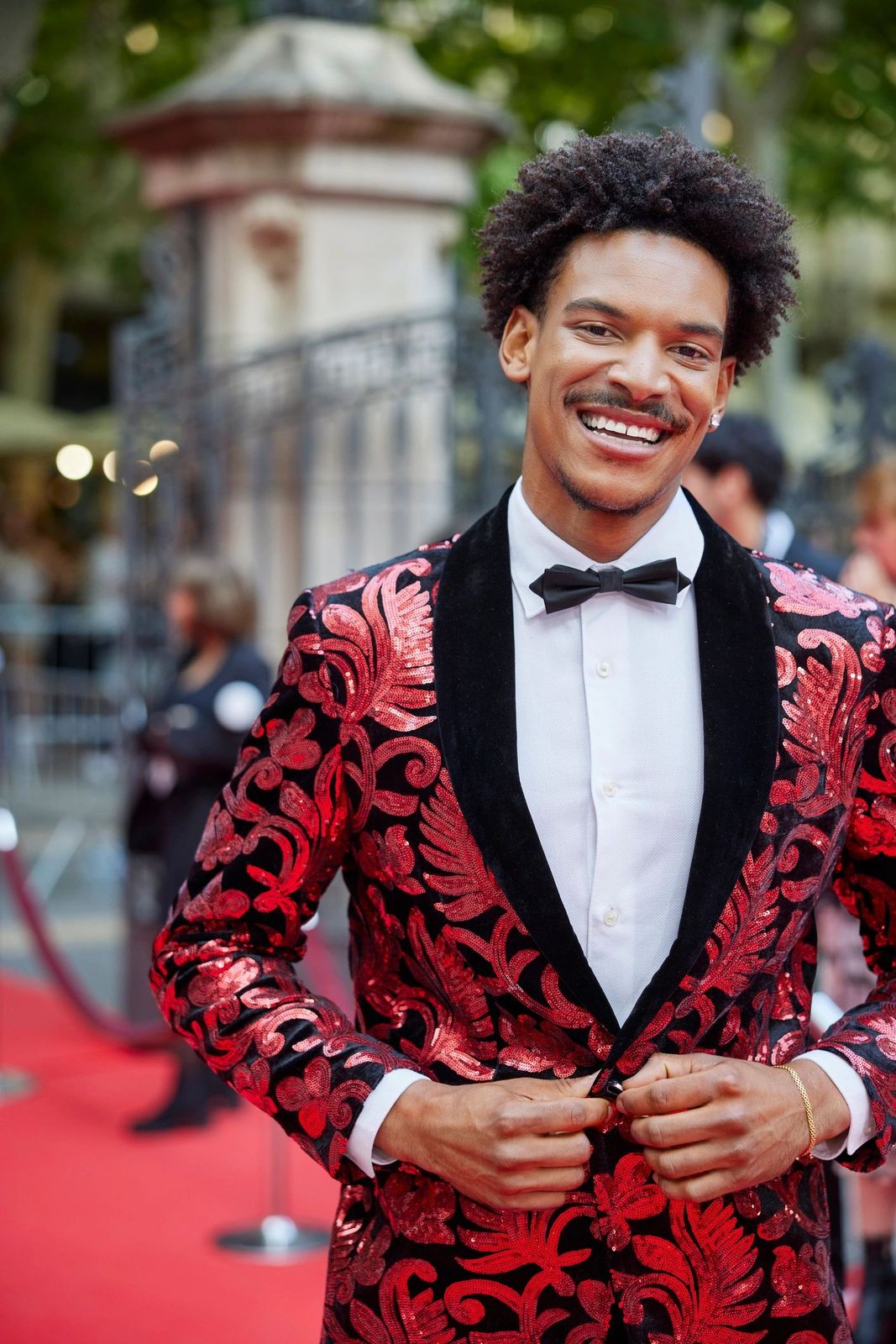 Guest on a red carpet in a sequinned jacket
